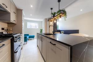 a kitchen with a large counter top in a room at Stunning 5BR house wgarden & terrace, SE London in London