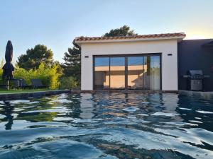 a swimming pool in front of a house at Villa de luxe en Provence Piscine Chauffée in Puget