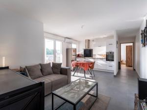 ein Wohnzimmer mit Sofa und Tisch in der Unterkunft AZALEE - Parking gratuit - Terrasse couverte - Proche transport - Tout équipé in Nancy