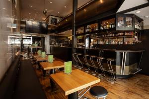 a restaurant with wooden tables and chairs and a bar at Hotel Loge in Winterthur