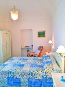 a bedroom with a blue bed and a chair at Casa Vacanze La Rosa Del Mare in Amalfi