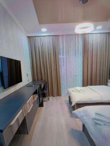 - une chambre à l'hôpital avec 2 lits et une télévision dans l'établissement usjwjeeu, à Yakkasaray