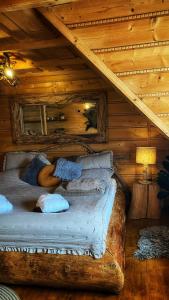 a log bed in a log cabin with a roof at Gorący Potok Apartamenty in Szaflary