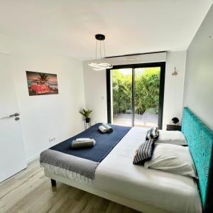 - une chambre avec un grand lit et une grande fenêtre dans l'établissement La Villa Canopée - Piscine chauffée-Fibre-Clim-Jacuzzi, à Gujan-Mestras