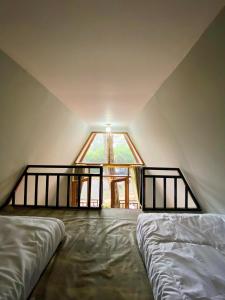 a attic room with two beds and a window at Great Panorama Lodge and Camping in Lembang