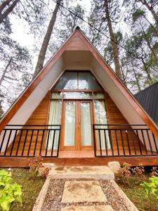 a small house with a large window in the woods at Great Panorama Lodge and Camping in Lembang