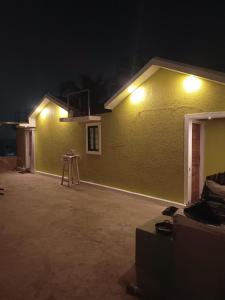 un edificio amarillo con dos luces encendidas por la noche en Budget-Friendly Luxury Air-Conditioned Deluxe Suite at Pravuprasad Homestay, en Bhubaneshwar