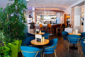 un restaurant avec des chaises bleues et un bar dans l'établissement Hôtel & Restaurant des Remparts, à Rochefort
