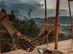 a hammock on top of a deck with a view at Petrichor - Regenerative Living Experience in Gorubathān