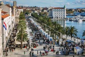 a group of people walking on a street near the water at Apartment Džoni in Split