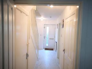 a hallway with white walls and a white door at Harrow Home in Harrow