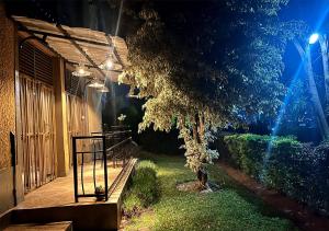 a porch of a house with a tree in the yard at Cosy Hidden Gem in Kigali