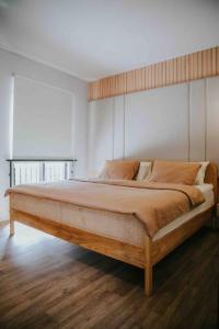 a bedroom with a large bed with a wooden headboard at Twelve Stones at Wahoo KBP in Padalarang