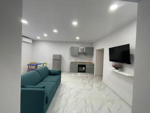 那不勒斯Isla Home的带蓝色沙发的客厅和厨房