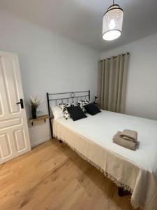1 dormitorio con 1 cama blanca grande con almohadas negras en Acogedor Apartamento Casco Histórico de Tarazona, en Tarazona de Aragón