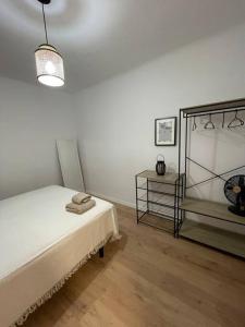 Habitación blanca con cama y mesita de noche en Acogedor Apartamento Casco Histórico de Tarazona, en Tarazona de Aragón