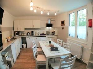 a kitchen with white cabinets and a table and chairs at Unterkunft4You-Ferienhaus-Am-Schloss in Usingen