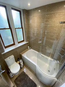 a bathroom with a tub and a toilet and a sink at 3-Bed Flat Central London, 6 Min Walk from King's Cross Station in London