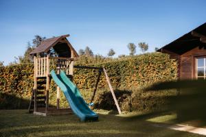 a playground with a slide next to a house at Villa Gramolina Nizza in Nizza Monferrato