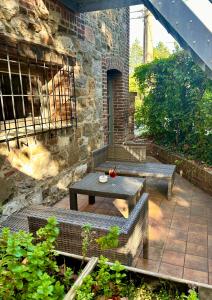 un patio con 2 bancos y una mesa en Les Chambres T4, en Huy