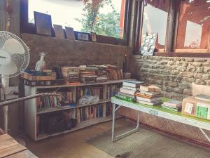 een kamer met een boekenplank gevuld met boeken bij Petrichor - Regenerative Living Experience in Gorubathān