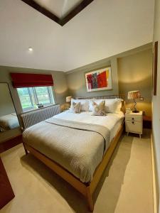 Un dormitorio con una cama grande y una ventana en Stone Barn, en Farnham