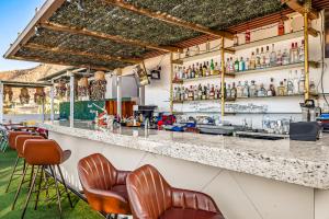 Um bar com uma fila de bancos à frente. em Alina 203a @ Morgan Residences em Cabo San Lucas
