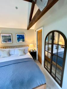 a bedroom with a blue bed and a window at Stone Barn in Farnham