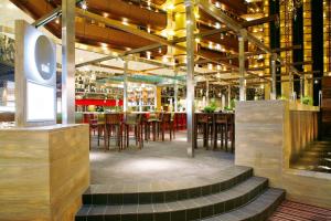 a restaurant with a bar with tables and chairs at Sandton Sun and Towers in Johannesburg
