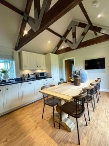 a large kitchen with a wooden table and chairs at Stone Barn in Farnham