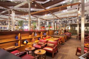 a restaurant with wooden tables and red chairs at Sandton Sun and Towers in Johannesburg