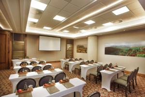 a conference room with tables and chairs and a screen at Sandton Sun and Towers in Johannesburg