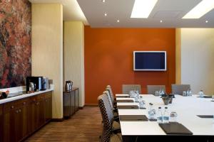 a conference room with a long table and a television at Sandton Sun and Towers in Johannesburg