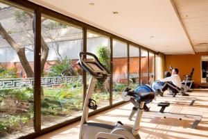 a room with a gym with people sitting in chairs and a treadmill at Sandton Sun and Towers in Johannesburg
