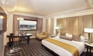 a hotel room with a large bed and a desk at Sandton Sun and Towers in Johannesburg