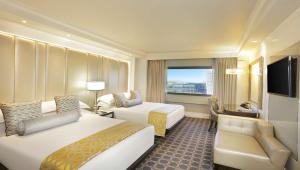 a hotel room with two beds and a television at Sandton Sun and Towers in Johannesburg