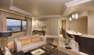 a living room with a couch and a table and a kitchen at Sandton Sun and Towers in Johannesburg