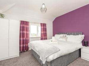 um quarto com paredes roxas e uma cama grande em Pass the Keys Large Family Getaway em Leeds