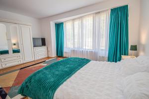 a bedroom with a large bed and a large window at Pensiune Forest Park in Baia Mare
