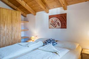 科萊皮耶特拉的住宿－Tschigghof，卧室配有一张床,墙上挂有绘画作品