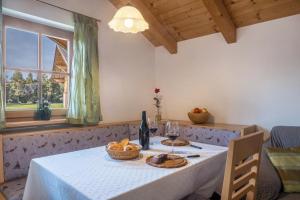 a table with a white table cloth and a bottle of wine at Tschigghof in Collepietra