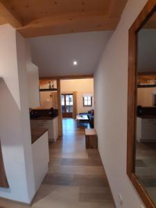 a kitchen with white walls and wooden floors and a mirror at Hochalmbahnen Chalets Rauris 1-09 WE2, Maislaufeldweg 1i OG in Rauris