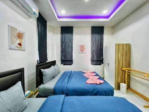 1 dormitorio con 2 camas y techo púrpura en Pangpangpuriyeh Poolvilla en Ban Pa Khan