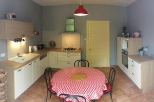 a kitchen with a table with a red and white table cloth at Gîte de vacances avec jardin arboré in Nieul-le-Dolent