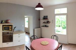 a kitchen with a table and a kitchen with a microwave at Gîte de vacances avec jardin arboré in Nieul-le-Dolent