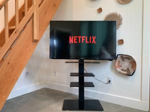 a television on a stand with the netflix sign on it at Private, stylish guest home in Victoria near Galloping Goose Trail in Victoria