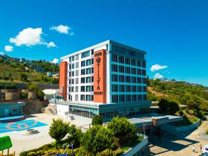 a tall white building with a sign on it at Tilya Resort Hotel in Trabzon