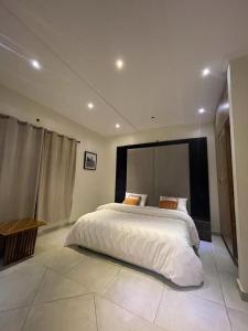 a bedroom with a large white bed in a room at AlanVal Apartments in Accra