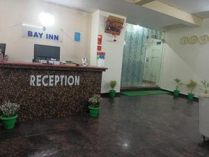 a lobby with a pay inn reception in a room at Bay Inn in Puri