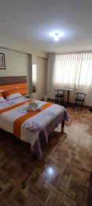 ein Schlafzimmer mit einem großen Bett und einem Tisch in der Unterkunft Aruba Suite Hotel in Lima